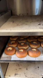 מתכון חדש לבייגל אמריקאי שרק מחכה שנשדך לו גבינת שמנת וחביתה.
תשמרו את המתכון הזה

חומרים לבצק ל-14 יחידות:

ק”ג קמח לחם מנופה
10 גרם שמרים יבשים
20 גרם סוכר
580 מ”ל מים
4 כפיות דבש
20 גרם מלח
30 גרם שמן זית

למי הבישול:
4 ליטר מים
2 כפות סודה לשתייה
חצי כוס סילאן

אופן ההכנה:
מתחילים יום קודם: מתפיחים ומעצבים את הבצק במקרר במשך לילה שלם.ביום למחרת מבשלים ואופים.
מכינים את הבצק: בקערת המיקסר עם וו לישה שמים לפי הסדר: מים, שמרים, סוכר, דבש וקמח, לשים כ- 4 דקות על מהירות בינונית, מוסיפים שמן ומלח ולשים 7 דקות נוספות עד לקבלת בצק אחיד וחלק למגע
מוציאים את הבצק מקערת המיקסר, מעצבים לכדור יפה, מניחים על השיש, משמנים מעט את כדור הבצק, מכסים היטב ונותנים לבצק לנוח 15 דקות
מעצבים ומתפיחים במקרר למשך לילה: מחלקים את הבצק ל-14 חלקים שווים, כל חתיכת בצק במשקל 120 גרם, מגלגלים ומעצבים לכדור יפה שפניו מתוחות, עושים חור בעזרת האצבע במרכז הכדור ופותחים לצורת בייגל עגול
מניחים את הבייגלים שעיצבנו בתבנית עם נייר פרגמנט משומן או סילפט(סיליקון) ברווחים אחד מהשני (הם תופחים במקרר) ועוטפים בשקית ניילון גדולה, מעבירים למקרר ל: 8-12 שעות
ביום למחרת מכינים את נוזל הבישול: שמים בסיר גדול 4 ליטר מים, סודה לשתייה וסילאן ומביאים לרתיחה
מחממים את התנור לחום של 220 מעלות חום עליון תחתון
מבשלים: מכניסים את הבייגלס התפוחים ישר מהמקרר לסיר,4 בכל נגלה, מבשלים אותם כדקה, הופכים אותם לצד השני
מוציאים את הבייגל בעזרת כף מחוררת ומניחים במרווחים אחד מהשני על גבי תבנית מרופדת בנייר אפייה, מפזרים מעליהם פרג
אופים בתנור שחומם מראש לחום של 220 מעלות כ- 20 דקות עד להזהבה יפה
מצננים ומגישים
#bagel #bagels #yum #bakingfromscratch #מתכוןמנצח #מתכון #בייגלאמריקאי #יאמי