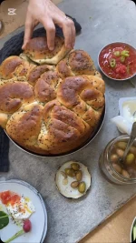 ⁨	מתכון לקובנה מדהימה שאפיתי בטאבון ממולאת בצל ירוק וקצח, מתכון שלי מספר הטאבון, אפשר להכין גם בתנור, תשמרו את המתכון הזה

החומרים:
ק”ג קמח לחם מנופה
10 גרם שמרים יבשים
100 גרם סוכר
580  גרם מים
30 גרם מלח
50 גרם קצח
80 גרם בצל ירוק חתוך לטבעות (רק החלק הירוק, חבילה)

חומרים לפתיחת הבצק:
100 גרם חמאה מומסת

סיר לקובנה בקוטר 26 ס”מ

אופן ההכנה:
בקערת המיקסר עם וו לישה מערבבים מים, שמרים וסוכר כחצי דקה
מוסיפים את הקמח ומערבבים כשתי דקות עד להיווצרות בצק אחיד
מוסיפים מלח ומערבבים כ 8-10 דקות נוספות
דקה לפני סיום הלישה מוסיפים קצח ובצל ירוק וממשיכים ללוש
הבצק צריך להיות גמיש וחלק למגע
התפחה ראשונה: מוציאים את הבצק מהקערה, מעצבים לכדור ומעבירים אותו לקערה משומנת מעט ומכוסה במגבת, מתפיחים את הבצק בטמפ’ החדר כשעה וחצי או עד אשר הבצק מכפיל את נפחו
שקילה: שוקלים ומחלקים את הבצק ל- 8 חלקים שווים, כל חתיכה במשקל 235 גרם
כדרור: יוצרים מכל חתיכה של בצק כדור כשפניו יפים וחלקים
מנוחה 30 דקות: מורחים על כל כדור משני צדדיו חמאה מומסת. מניחים את הכדורים על תבנית מכסים בניילון ונותנים לכדורים לנוח כחצי שעה
אופן פתיחת הבצק בידיים:
מוציאים את הכדור שתפח ומעבירים אותו למשטח עבודה, מרדדים בעזרת מערוך את הכדור המשומן לאליפסה גדולה ודקה, מברישים את הבצק בחמאה מומסת
מגלגלים לצורת רולדה, את הרולדה מגלגלים לצורת שבלול
משמנים את כל דפנות הסיר הייעודי בחמאה ומסדרים את השבלולים אחד ליד השני בצפיפות ואת האחרון במרכז
מורחים מעט חמאה ומתפיחים כשעה וחצי בטמפ’ החדר מכוסה במגבת
אפייה בטאבון שחומם מראש לחום של 150 מעלות ריצפה ללא אש גלויה, אופים את הקובנה בסיר סגור כ 3-10 שעות, דלת הטאבון סגורה, לפני סיום האפייה מסירים את המכסה ואופים כחצי שעה נוספות עד להזהבה של הבצק
אפייה בתנור שחומם מראש לחום של 230 מעלות, אופים כ30 דקות מכוסה, מנמיכים את חום התנור ל 180 מעלות, אופים למשך שעה, מסירים את המכסה ואופים כעשר דקות נוספות עד להזהבה של הבצק

#מתכון #טאבון #קובנה #מתכוןלטאבון #יאמי #אוכל⁩