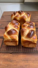 חלות לשבת שאפיתי בתבנית, כי אין על חלות בשישי, תשמרו את המתכון הזה

חומרים לשלוש חלות:

קילו קמח לחם (בקיץ קר מהמקרר)
15 גרם שמרים יבשים
50 גרם סוכר
50 גרם דבש
450 מ”ל מים (בקיץ מים קרים)
2 ביצים
50 גרם שמן זית
20 גרם מלח
לציפוי: ביצה טרופה קורט סוכר

אופן ההכנה
שמים בקערת המיקסר עם וו לישה מים, שמרים, סוכר, דבש, ביצים, מוסיפים קמח ולשים כשתי דקות
מוסיפים בהדרגה שמן, לשים 10 דקות עד שהבצק אחיד ורך למגע, שתי דקות לפני הסוף מוסיפים את המלח ומגבירים את מהירות המיקסר
התפחה ראשונה: מוציאים את הבצק מהקערה, לשים ידנית ומעצבים לצורת כדור, מעבירים את הבצק לקערה משומנת מעט בתחתית, נותנים לבצק לתפוח בקערה, מכוסה במגבת כשעה וחצי, עד לתפיחה מלאה
שקילה: מחלקים את הבצק ל-12 חלקים שווים
כדרור: מכדררים כל חתיכת בצק לכדור חלק ויפה, מניחים על מגש ומשמנים מעט את פני הכדור, מכסים במגבת וממתינים 10 דקות 
עיצוב ראשוני: מרדדים בעזרת מערוך כל כדור בצק לאליפסה ארוכה, מגלגלים כל אליפסה לגליל מהודק, מכסים במגבת ונותנים להם לנוח 10 דקות
עיצוב סופי: פותחים כל גליל לצורת נחש, מניחים 4 רצועות לאורך ומצמידים את הקצוות, קולעים את החלה
התפחה: מניחים את החלות הקלועות בתבנית גבוהה ומשומנת מעט, מברישים את החלות בביצה טרופה, מתפיחים כשעה וחצי או עד הכפלת הנפח (תלוי מזג אוויר)מכוסות במגבת
הברשה שנייה: לאחר התפיחה ולפני הכניסה לתנור מברישים בעדינות את החלות שוב בביצה 
אפייה: אופים בתנור שחומם מראש לחום של 185 מעלות, אני אופה בתוכנית חום עליון תחתון למשך כ- 25-28 דקות
מוציאים מהתבנית ומעבירים לרשת צינון

מידות התבנית בהן השתמשתי : גובה 11 ס”מ, אורך 20 ס”מ , רוחב 11 ס”מ